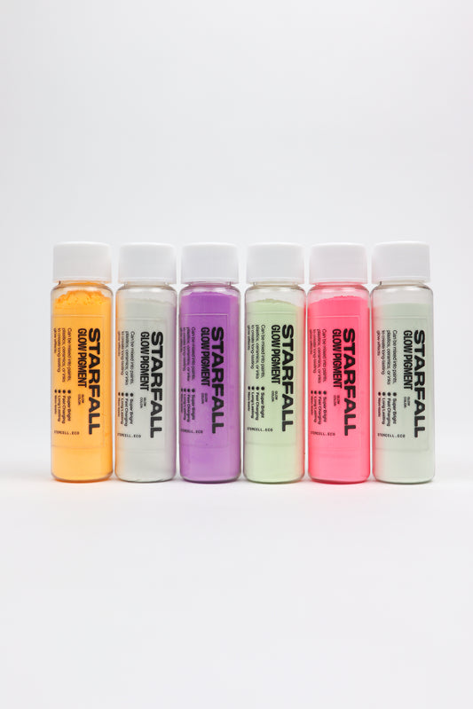 Set of Starfall glow powder bottles in various colors on a white background