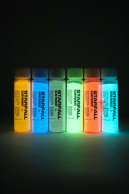 Set of six bottles of Starfall glow paint glowing in a dark setting