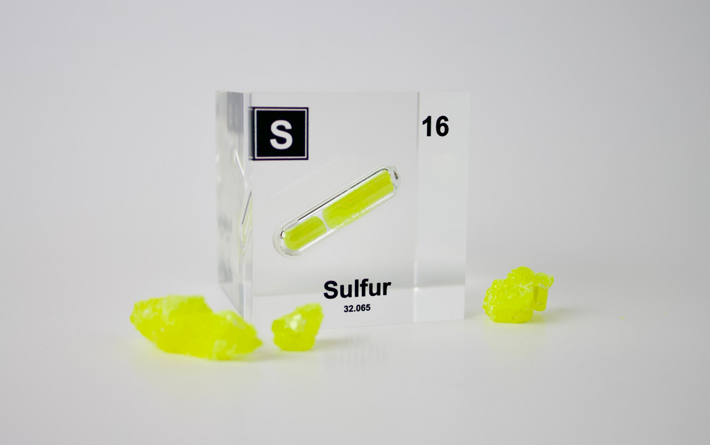 Sulfur sample with a clear box labeled 'S' on a white background